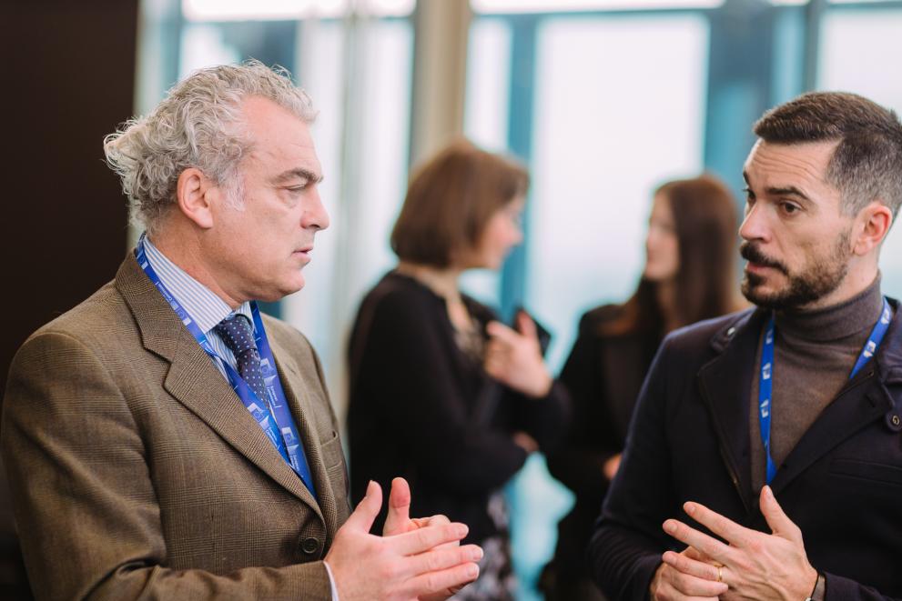 Two men discussing during the EUSIC event.