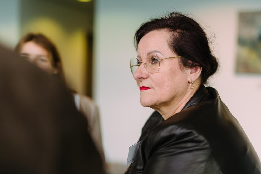 Woman in glasses during the EUSIC event.